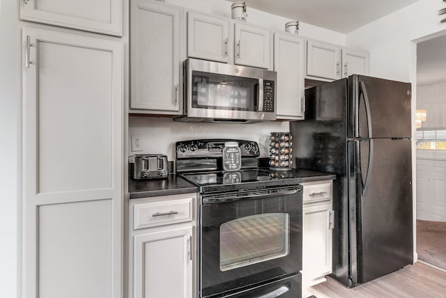 kitchen with white cabinets, light hardwood / wood-style flooring, and black appliances