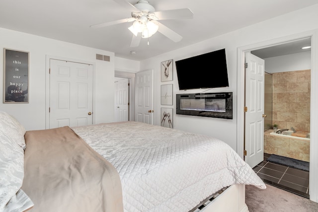 bedroom featuring carpet, ensuite bath, and ceiling fan