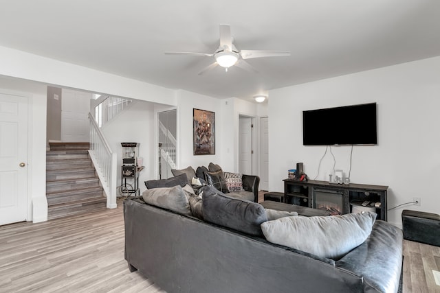 living room with light wood-type flooring and ceiling fan