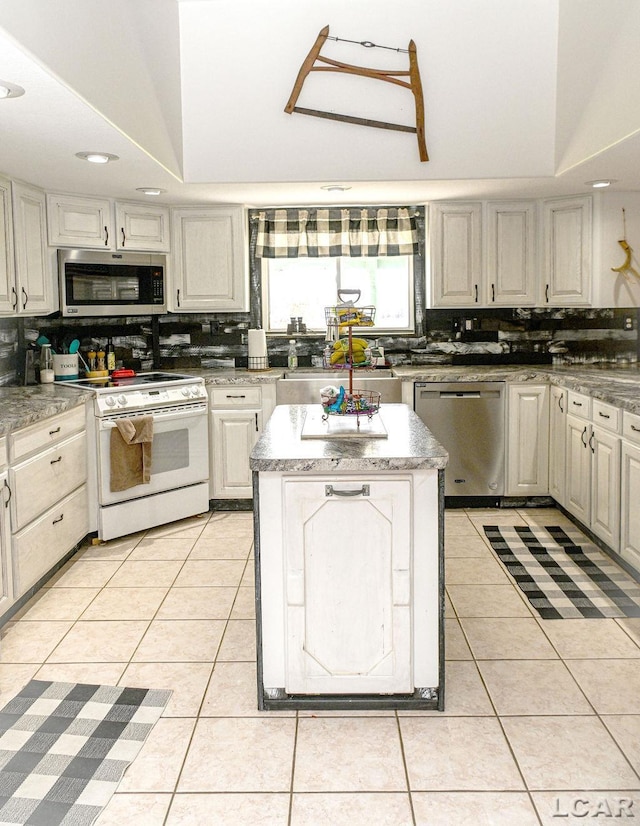 kitchen with a center island, light tile patterned floors, stainless steel appliances, and tasteful backsplash