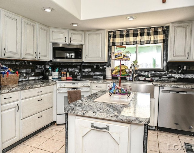 kitchen with backsplash, a center island, white cabinets, and stainless steel appliances