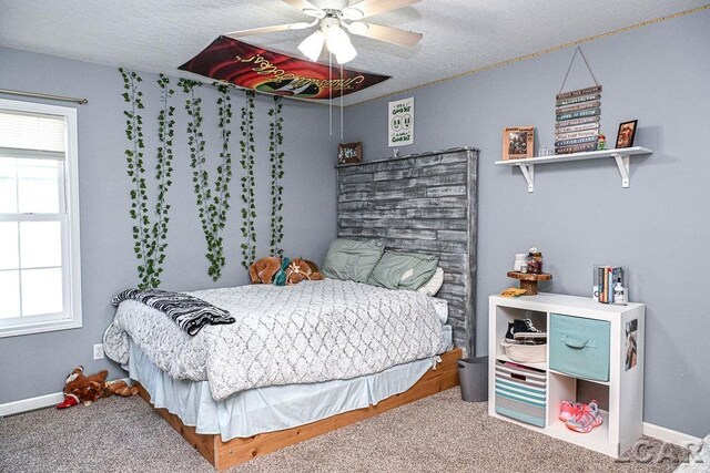 carpeted bedroom featuring a textured ceiling and ceiling fan