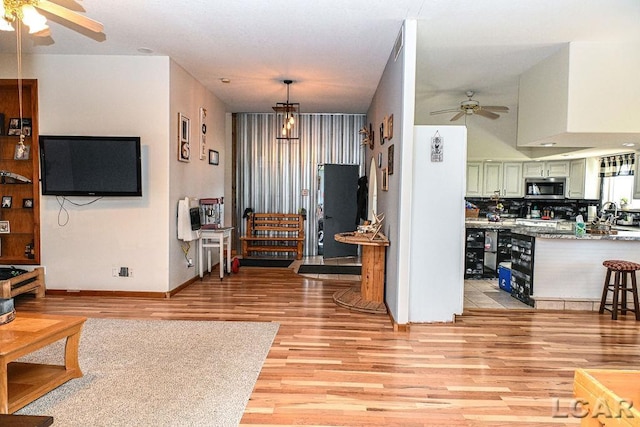 living room featuring light hardwood / wood-style flooring and ceiling fan