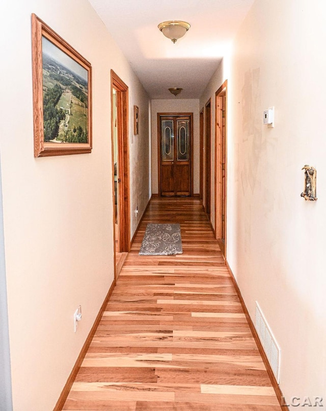 corridor with light wood-type flooring