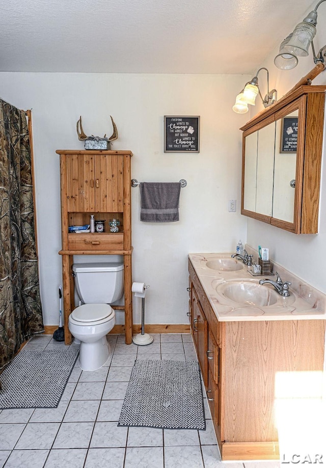 bathroom with tile patterned flooring, vanity, and toilet