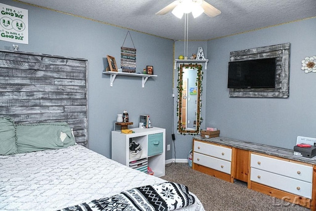 bedroom with ceiling fan, carpet floors, and a textured ceiling