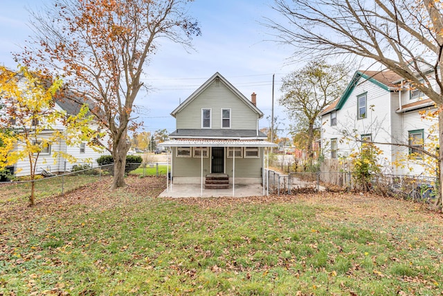 back of property with a patio area and a lawn