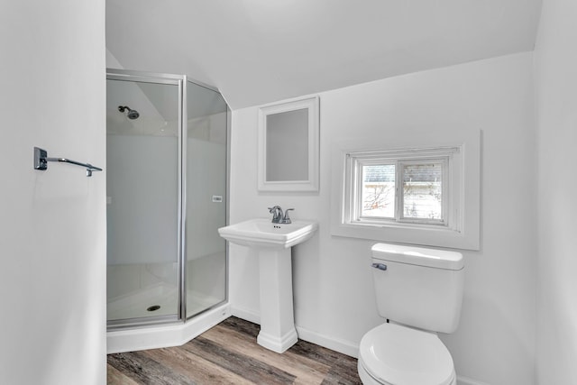 bathroom with hardwood / wood-style floors, toilet, a shower with shower door, and sink