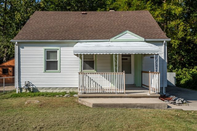 view of front of home with covered porch and a front lawn