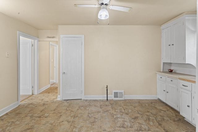 interior space featuring white cabinets and ceiling fan