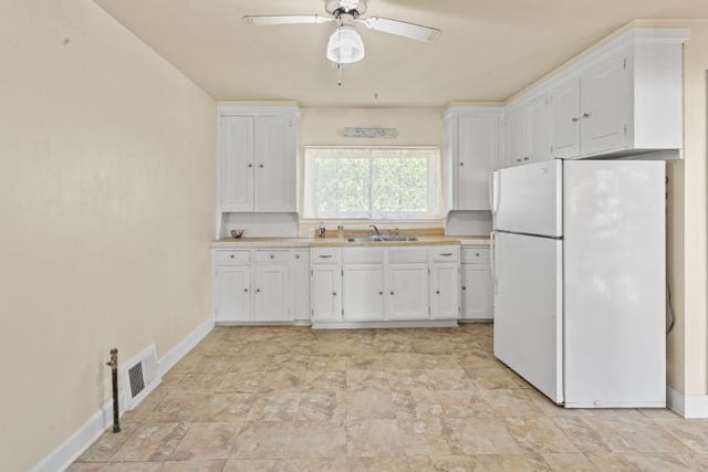 kitchen with ceiling fan, sink, white cabinets, and white refrigerator