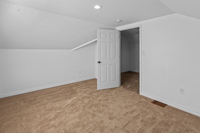 bonus room featuring light carpet and vaulted ceiling