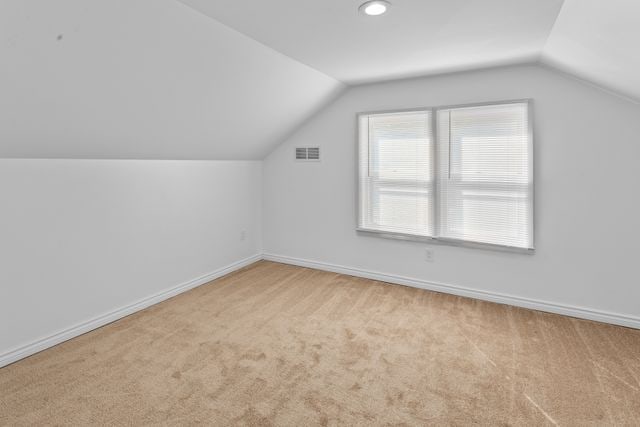 additional living space with light carpet and lofted ceiling