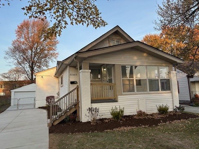 bungalow with a porch, an outdoor structure, and a garage