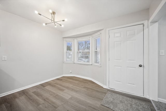 unfurnished bedroom with a chandelier and wood-type flooring