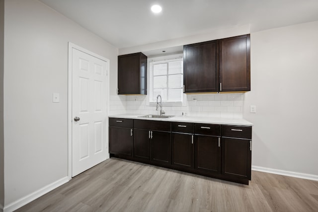 kitchen with sink, light hardwood / wood-style floors, and dark brown cabinets