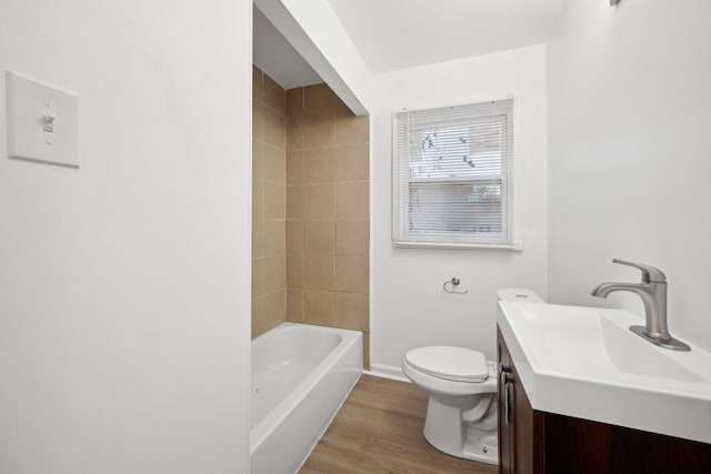 full bathroom with vanity, hardwood / wood-style flooring, toilet, and tiled shower / bath combo