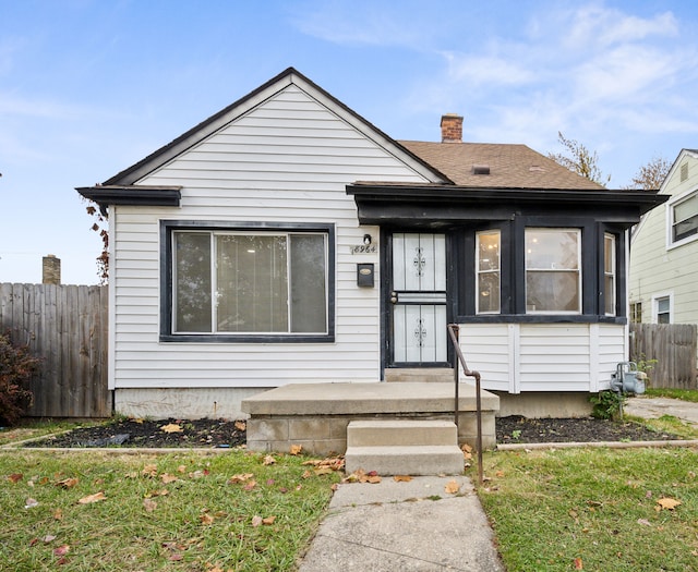 bungalow-style home with a front yard