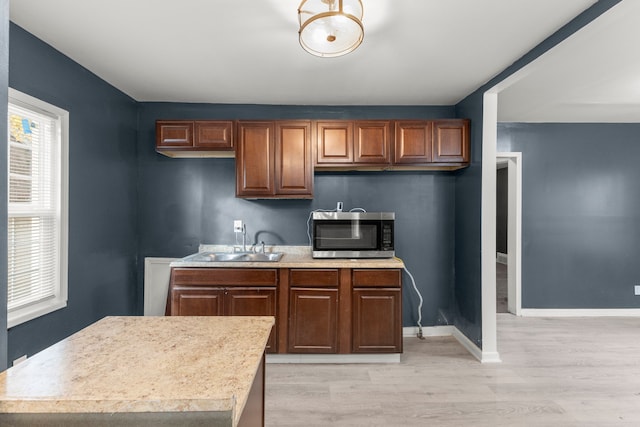 kitchen with a center island, light hardwood / wood-style flooring, and sink