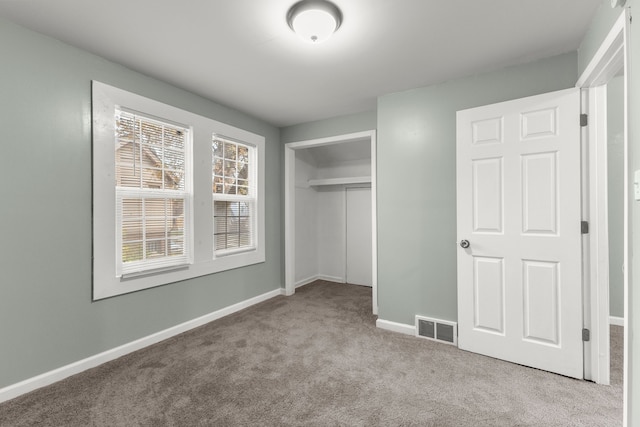 unfurnished bedroom with light carpet and a closet