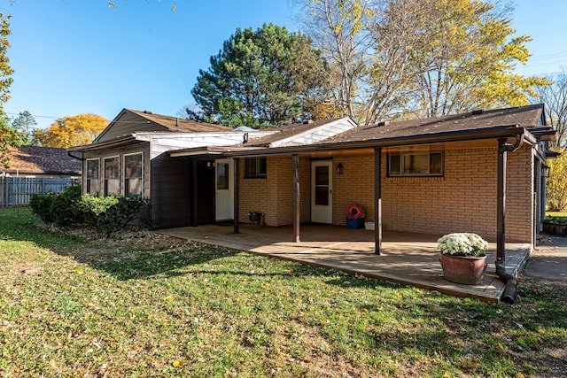 back of house featuring a patio and a lawn