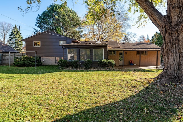 back of property with a yard and a patio