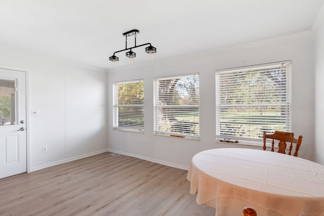 dining area with crown molding and light wood-type flooring