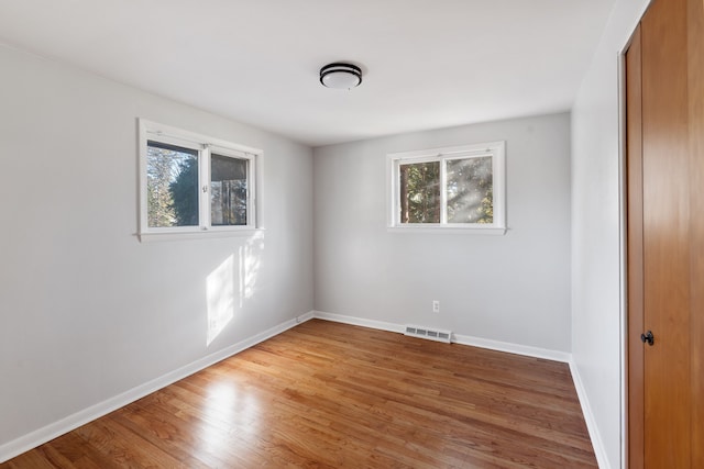 unfurnished room featuring wood-type flooring and a wealth of natural light