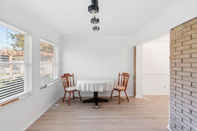 dining area with light wood-type flooring and crown molding