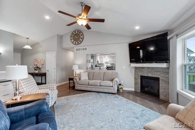 living room with a fireplace, ceiling fan, dark wood-type flooring, and vaulted ceiling