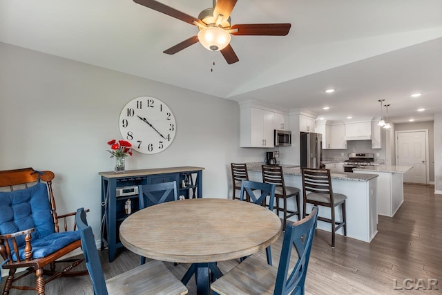 dining space featuring hardwood / wood-style floors, ceiling fan, and lofted ceiling