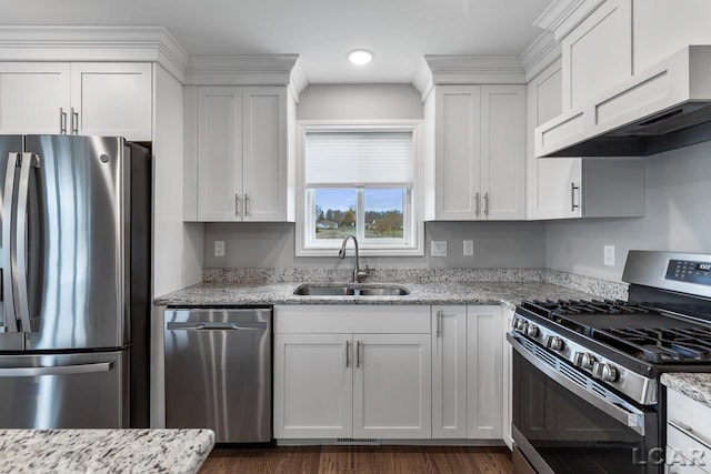 kitchen with light stone countertops, appliances with stainless steel finishes, custom exhaust hood, sink, and white cabinets