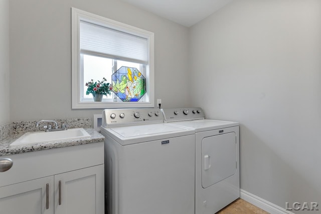 washroom featuring washing machine and dryer, sink, and cabinets