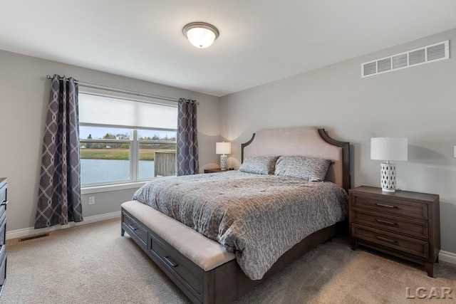 bedroom with light carpet and a water view