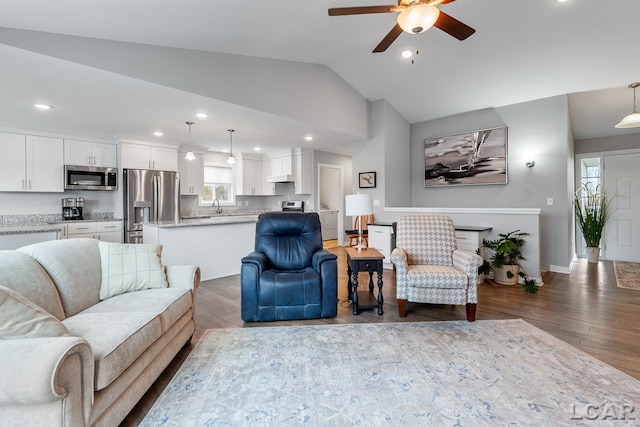 living room with hardwood / wood-style floors, ceiling fan, lofted ceiling, and sink