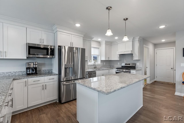 kitchen with white cabinets, dark hardwood / wood-style flooring, light stone counters, and appliances with stainless steel finishes