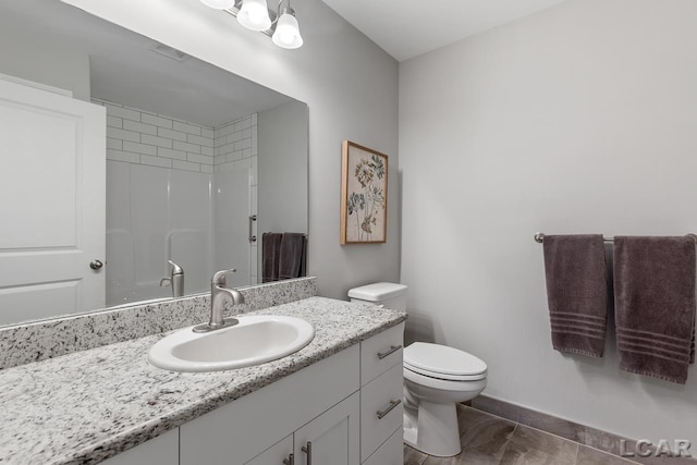 bathroom featuring tile patterned floors, toilet, vanity, and walk in shower