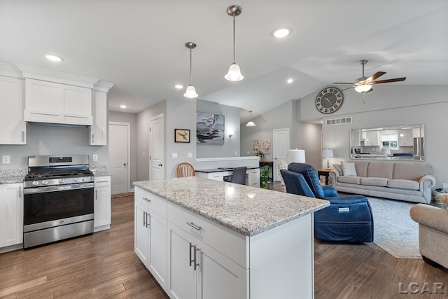 kitchen featuring white cabinets, vaulted ceiling, stainless steel gas range, ceiling fan, and dark hardwood / wood-style flooring