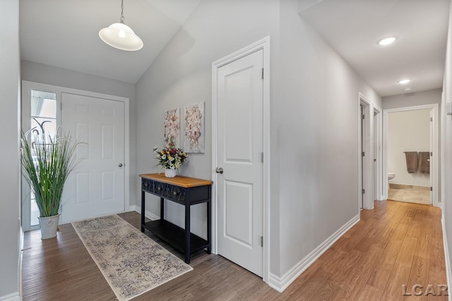 foyer entrance with hardwood / wood-style flooring and vaulted ceiling