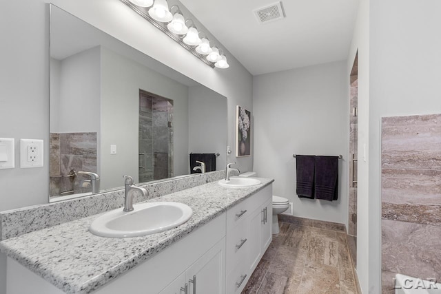 bathroom with vanity, toilet, and an enclosed shower