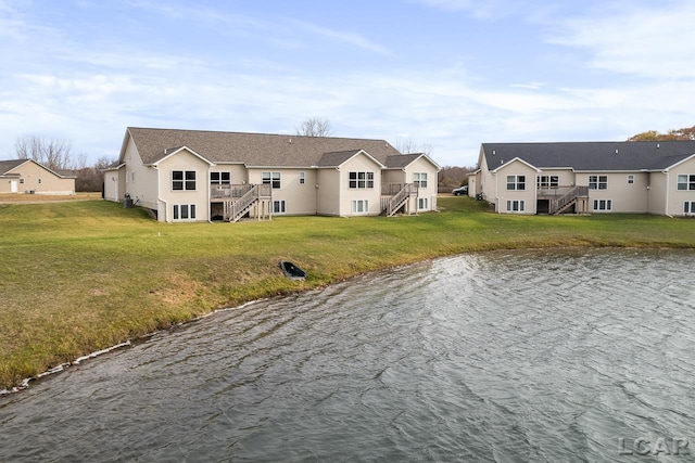 exterior space with a water view and a lawn