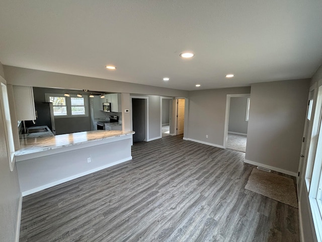 kitchen featuring sink, dark wood-type flooring, stainless steel appliances, kitchen peninsula, and white cabinets