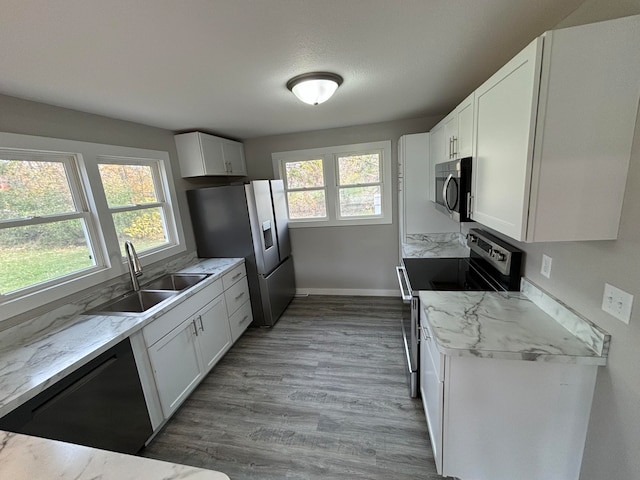 kitchen featuring white cabinets, a healthy amount of sunlight, sink, and appliances with stainless steel finishes