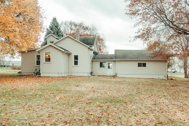 rear view of house featuring a yard