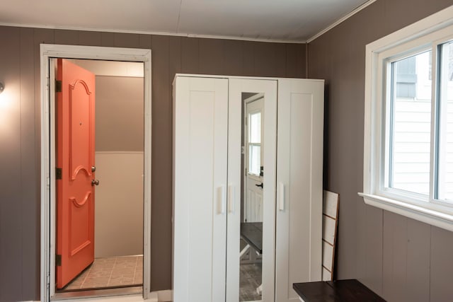 interior space with wood walls and ornamental molding