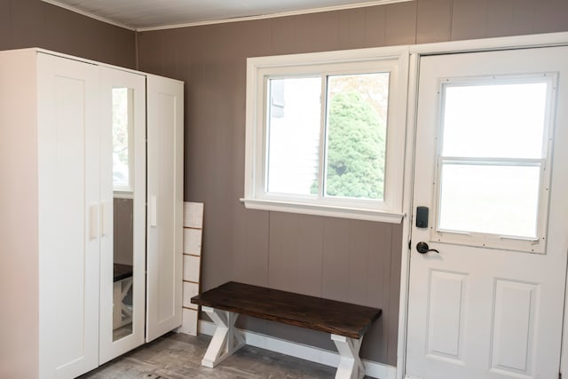 doorway with light hardwood / wood-style floors and wooden walls