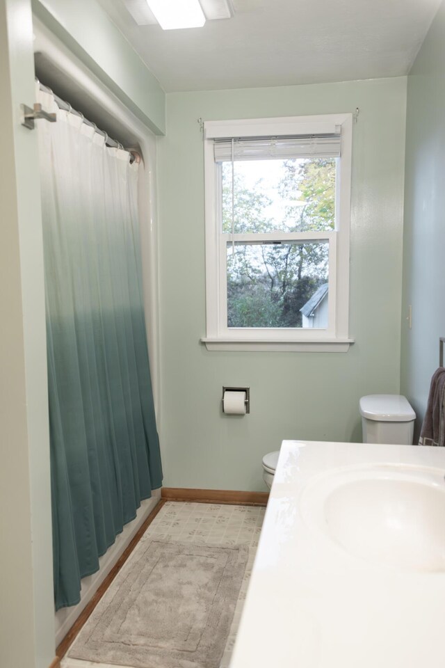 317 Maiden Ln, Saint Joseph, MI 49085 - full bath featuring toilet, baseboards, curtained shower, and a sink