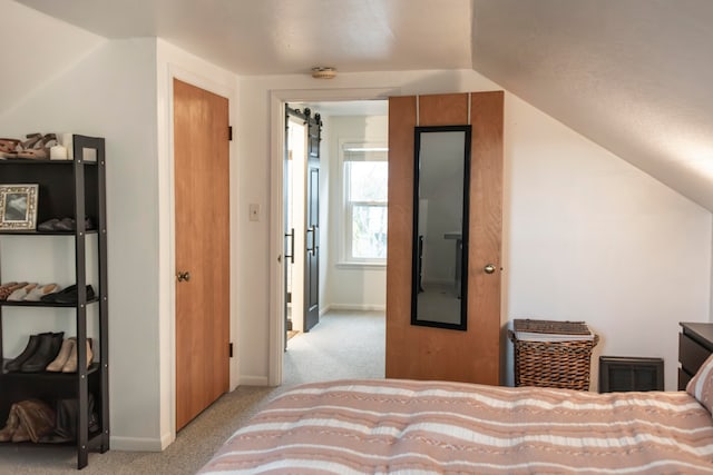 bedroom with a closet, light colored carpet, and lofted ceiling