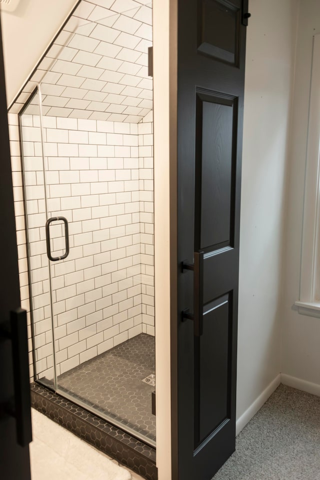 bathroom featuring a shower with door