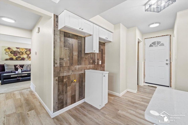 kitchen with white cabinetry and light hardwood / wood-style flooring